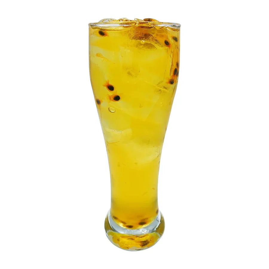 Verre haut de boisson glacée jaune avec graines de fruit de la passion, rafraîchissant et fruité