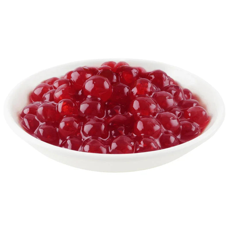 Perles de boba rouge grenade dans un petit bol blanc, topping pour bubble tea