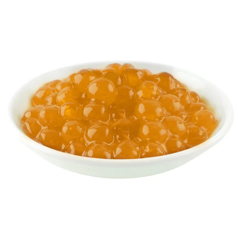 Perles de tapioca pêche dorée dans un bol blanc, topping boba pour boissons et desserts