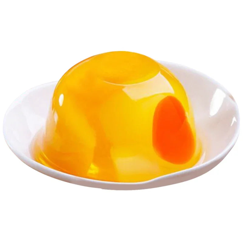Gelée jaune translucide en forme de dome avec un insert orange sur une assiette blanche