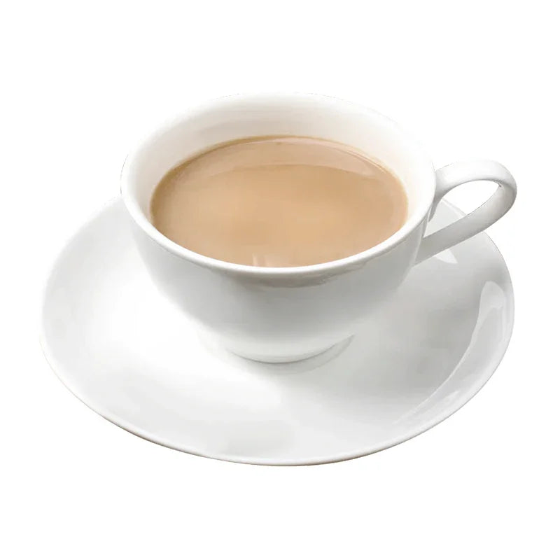 Tasse blanche de thé au lait sur une soucoupe blanche, boisson chaude crémeuse