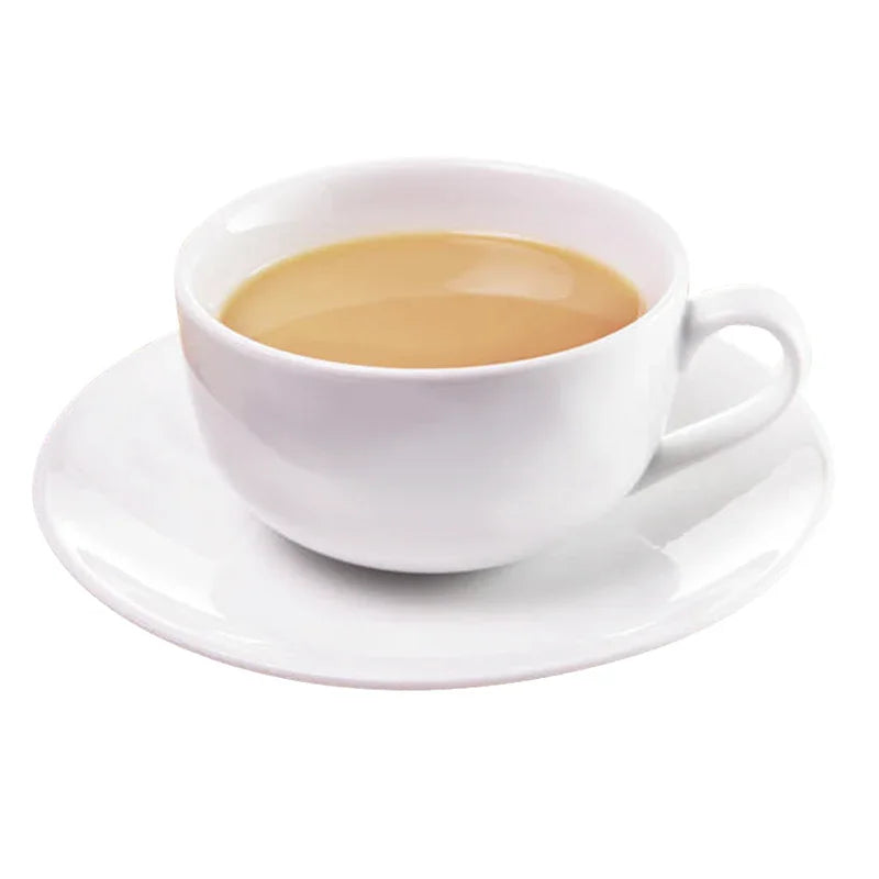Tasse blanche remplie de thé au lait vanille sur une soucoupe blanche, fond blanc