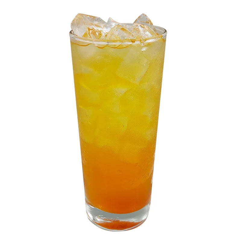 Verre rempli de cocktail jaune orangé aux glaçons, boisson fraîche fruit de la passion