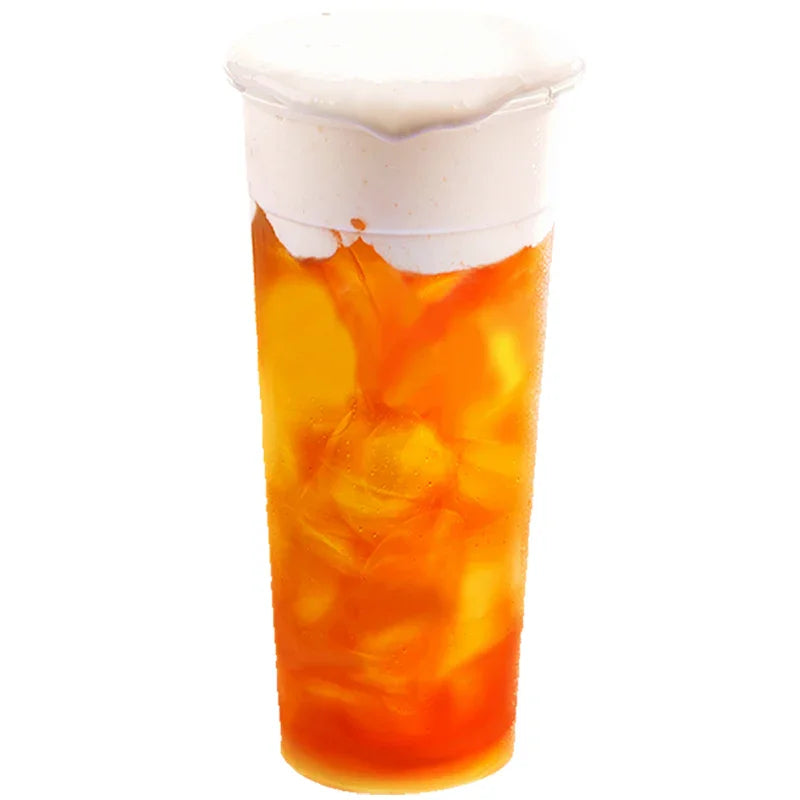 Boisson glacée au thé avec mousse salée rose en verre transparent